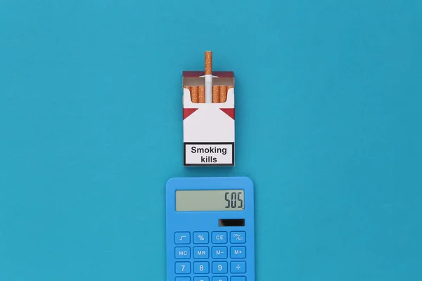 Mavi Arka Planda Bir Paket Sigara Hesap Makinesi Sigara Maliyetleri — Stok fotoğraf