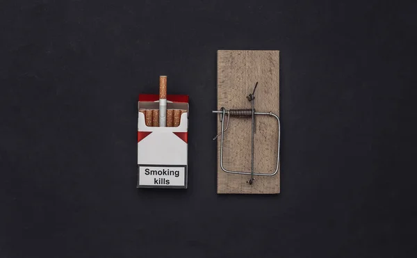 吸烟成瘾 黑色背景下的捕鼠器和香烟包 — 图库照片
