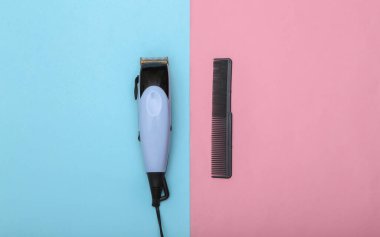 Pembe mavi arka planda saç makası ve tarak. Berber aleti. Üst görünüm