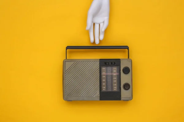 Mankenin Beyaz Eli Sarı Arka Planda Retro Radyo Alıcısı Tutuyor — Stok fotoğraf
