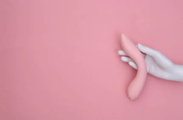 白色的人体模特手拿着粉色粉刷背景的女性性爱玩具 顶部视图 最低限度主义 — 图库照片