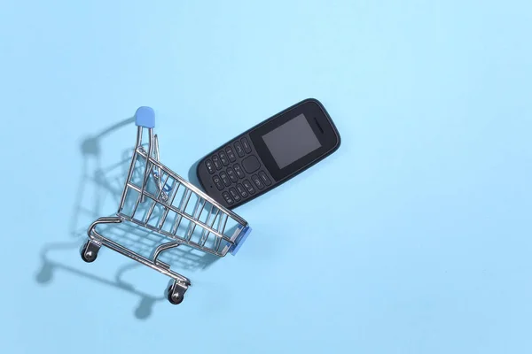 Shopping Vagn Med Tryckknapp Telefon Blå Bakgrund Ovanifrån — Stockfoto