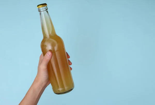 Mano Sostiene Botella Cerveza Sobre Fondo Azul —  Fotos de Stock