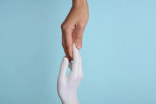 Een Menselijke Hand Raakt Hand Van Mannequin Blauwe Achtergrond Concept — Stockfoto