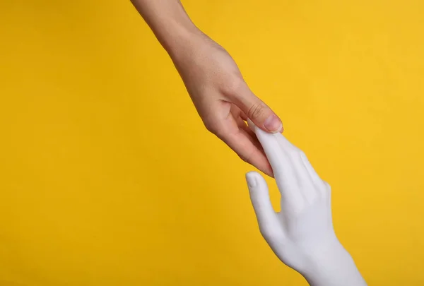 Bir Insan Eli Sarı Arka Plandaki Mankenin Eline Dokunur Yapay — Stok fotoğraf