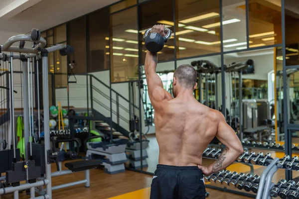 在现代体育馆里 以锻炼为重点的肌肉塑形男人带着水壶进行锻炼 健美力量训练 — 图库照片