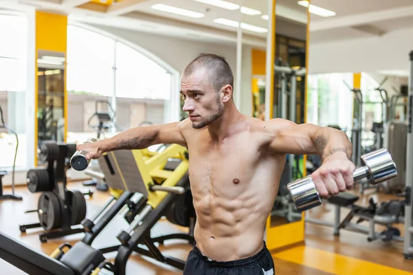 Bonito Fisiculturista Muscular Homem Treina Músculos Ombro Levantando Halteres Com — Fotografia de Stock