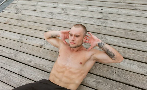 Male Bodybuilder Naked Torso Trains Abdominal Muscles Doing Crunches Lying — Stock Photo, Image