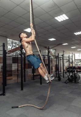 Modern bir sağlık kulübünde kaslı bir adam ip gerer. Fonksiyonel eğitim