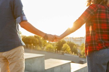 Gün doğumunda genç aşıklar el ele tutuşur. Birlikte vakit geçirmek. Aşk konsepti