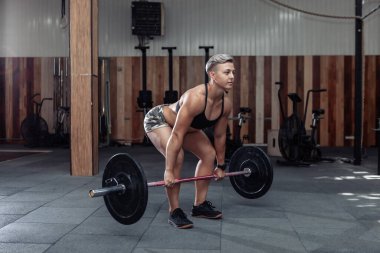 Güçlü kaslı kadın sporcu spor salonunda ağırlık kaldırma egzersizi yapıyor. Sağlıklı bir yaşam tarzı. Vücut geliştirme ve fitness. Cross, işlevsel eğitim