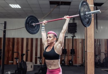 Güçlü ve güçlü vücut geliştirme ustası modern spor salonunda ağır halterlerle iş yapıyor. İşlevsel eğitim. Vücut geliştirme ve Fitness