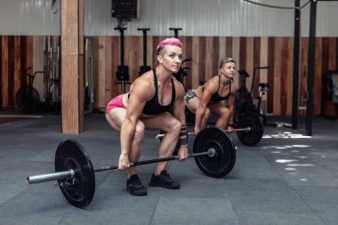 Güçlü kaslı kadın sporcu spor salonunda ağırlık kaldırma egzersizi yapıyor. Sağlıklı bir yaşam tarzı. Vücut geliştirme ve fitness. Çapraz, işlevsel eğitim sınıfı