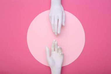 Mankenin beyaz elleri pembe arka planda birbirine dokunur. Minimalizm. Sanat kavramı