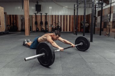 Modern sağlık kulübünde halterle egzersiz yapan kaslı bir sporcu. Vücut geliştirme ve Fitness