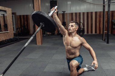 Modern sağlık kulübünde halterle egzersiz yapan kaslı bir sporcu. Vücut geliştirme ve Fitness