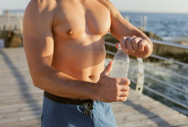 Мускулистий Чоловік Тримає Пляшку Води Сході Сонця Пляжі — стокове фото