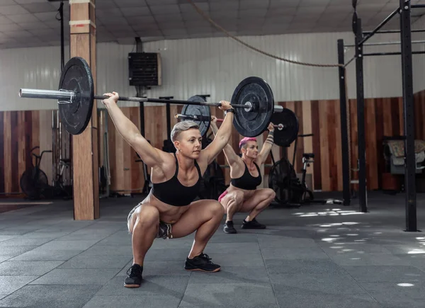 Güçlü kadın vücut geliştirici modern spor salonunda ağır halterlerle iş yapıyor. İşlevsel eğitim dersi. Vücut geliştirme ve Fitness