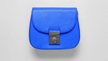Mavi arka planda mavi deri bir çanta. Minimalizm moda kavramı. Üst görünüm