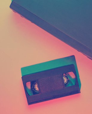 Retro dalga, minimalizm 80 'ler konsepti. Vhs kaseti olan video oynatıcı, neon ışık. Gece hayatı. Üst görünüm