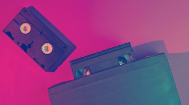 Retro dalga, minimalizm 80 'ler konsepti. Vhs kaseti olan video oynatıcı, neon ışık. Gece hayatı. Üst görünüm