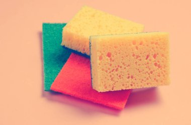 Pembe arka planda ev ve banyo temizleme seti. Süngerler, aşındırıcılar.