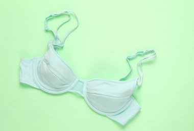 Yeşil arka planda mavi kadınsı sutyen. Üst görünüm, minimalizm