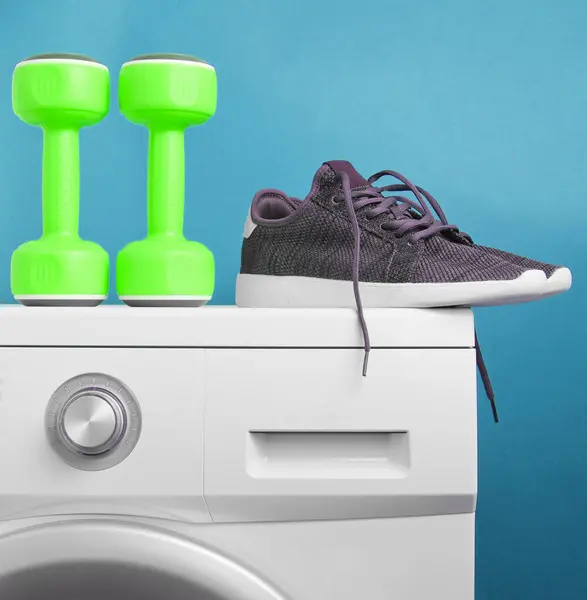 Grüne Kunststoffhanteln Sportschuhe Auf Waschmaschine Vor Blauem Hintergrund — Stockfoto