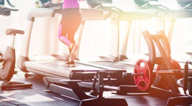 Spor salonundaki koşu bandında kardiyo eğitimi. Koşu bandında koşan kadın bacaklarının kesilmiş fotoğrafı.