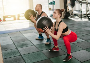 çift fonksiyonel eğitim. Sportif erkek ve formda kadın spor salonunda kettlebell ile egzersiz yapıyor.