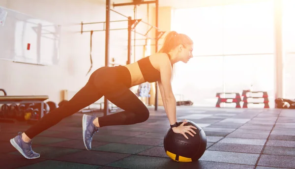 Атлетичная Привлекательная Женщина Делает Упражнение Поднимая Ногу Опираясь Медицинский Мяч — стоковое фото