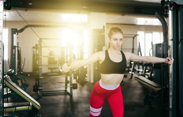 Ξανθιά Γυναίκα Τακτοποίηση Κάνει Άσκηση Στο Crossover Μηχάνημα Στο Γυμναστήριο — Φωτογραφία Αρχείου