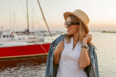 Genç neşeli sarışın kadının yaz portresi. Şapkalı ve güneş gözlüklü.