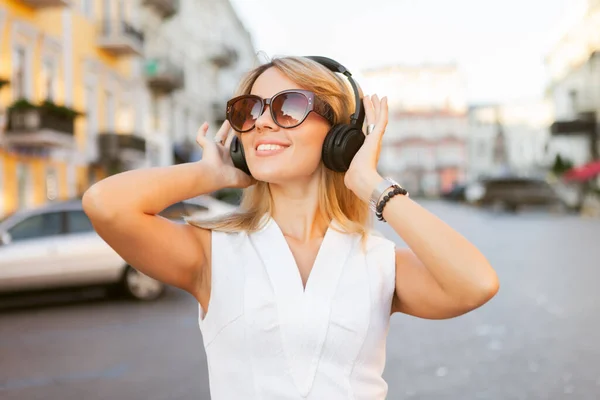 Молодая Веселая Женщина Солнечных Очках Слушает Музыку Наушниками Городе — стоковое фото