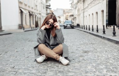 Genç, neşeli, güzel bir kadın Avrupa 'da bir caddenin ortasında oturuyor..