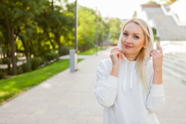 Açık havada beyaz kapüşonlu çekici kadın portresi.