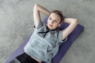 Paspasın üzerinde yatan sağlıklı genç bir kadının karın kaslarını eğitirken. Sağlıklı yaşam tarzı