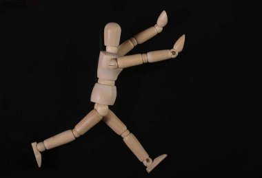 Siyah arka planda izole edilmiş tahta kukla mankeni.