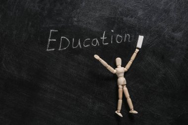 Tahtaya tebeşirli el ve tahta kukla çizilmiş kelime eğitimi.