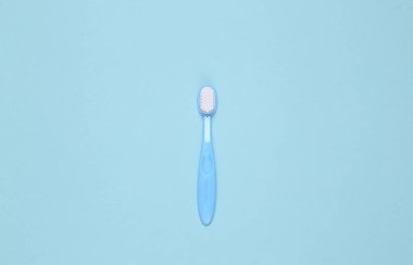 Mavi arka planda oyuncak diş fırçası. Üst Manzara. Minimalizm