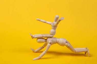 Babalık. Çocuklarla vakit geçirmek. İki kukla baba ve oğul birlikte vakit geçiriyorlar ve sarı arka planda oynuyorlar.