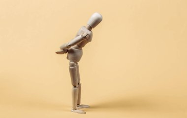 Üzgün ya da hayal kırıklığına uğramış sarı arka planda tahta kukla