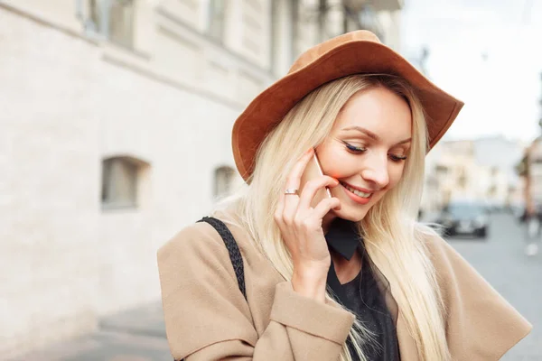 时髦的金发女人戴着毛毡帽在电话里聊天 城市里可爱女孩的画像 — 图库照片