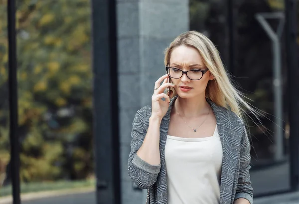 Seriöse Junge Attraktive Geschäftsfrau Telefoniert Vor Dem Hintergrund Einer Geschäftsstelle — Stockfoto