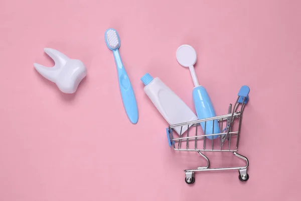 Spielzeug Zahnarzt Ausrüstung Einkaufswagen Auf Rosa Hintergrund Ansicht Von Oben — Stockfoto