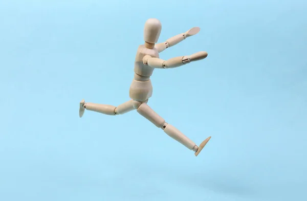 Весёлая Деревянная Кукла Прыгает Синем Фоне — стоковое фото