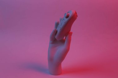 Manken eli kırmızı-mavi neon ışıkta joystick 'i tutuyor. Minimalizm