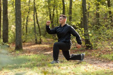 Aktif sporcu, sonbahar ormanlarında ısınma egzersizleri yapar. Sağlıklı bir yaşam tarzı. Açık hava egzersizi.