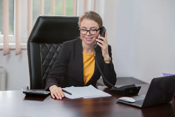 Business woman boss talking on the phone in her office