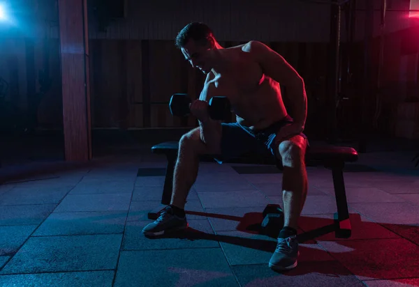 Muskulöser Mann Trainiert Bizeps Übung Mit Hantel Rot Blauem Steigungslicht — Stockfoto